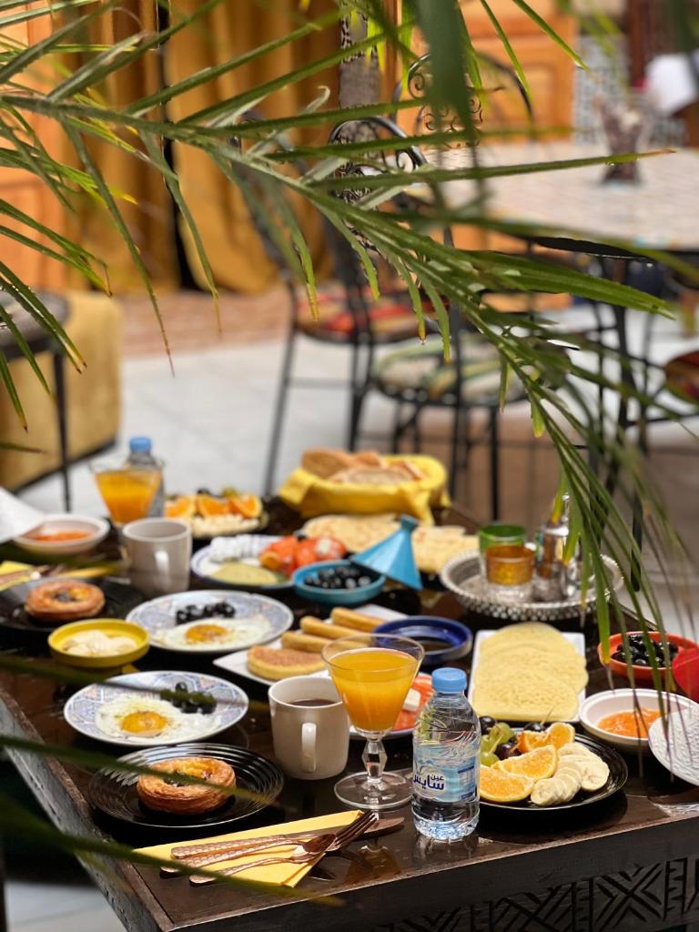 une table garnie d'assiettes de nourriture et de boissons dans l'établissement Riad Majorelle, à Rabat