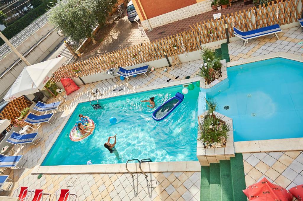 une vue aérienne d'une piscine avec des gens dedans dans l'établissement Hotel A Casa Nostra, à Rimini