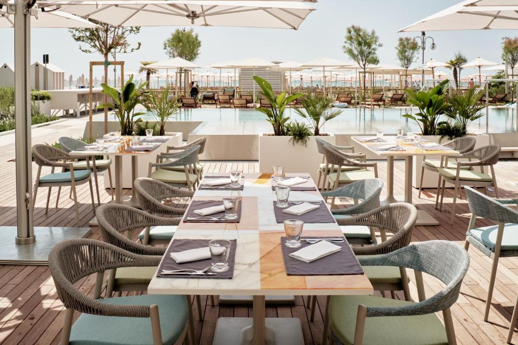 - un coin repas extérieur avec des tables et des chaises dans l'établissement Falkensteiner Hotel & Spa Jesolo, à Lido di Jesolo