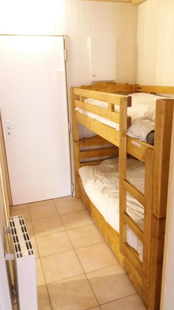 Cette chambre comprend deux lits superposés et un réfrigérateur. dans l'établissement Studio des Jeux - Alpe d'Huez Hyper Centre - 4-5 personnes - Wifi, à Huez