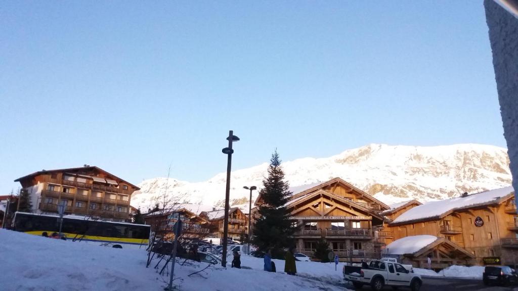 un lodge de ski avec des montagnes enneigées en arrière-plan dans l'établissement Studio des Jeux - Alpe d'Huez Hyper Centre - 4-5 personnes - Wifi, à Huez