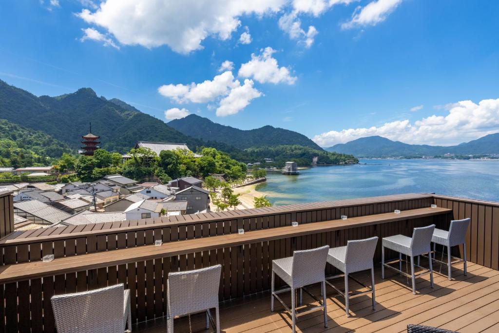 d'un balcon avec des chaises donnant sur la rivière et les montagnes. dans l'établissement Kinsuikan, à Miyajima