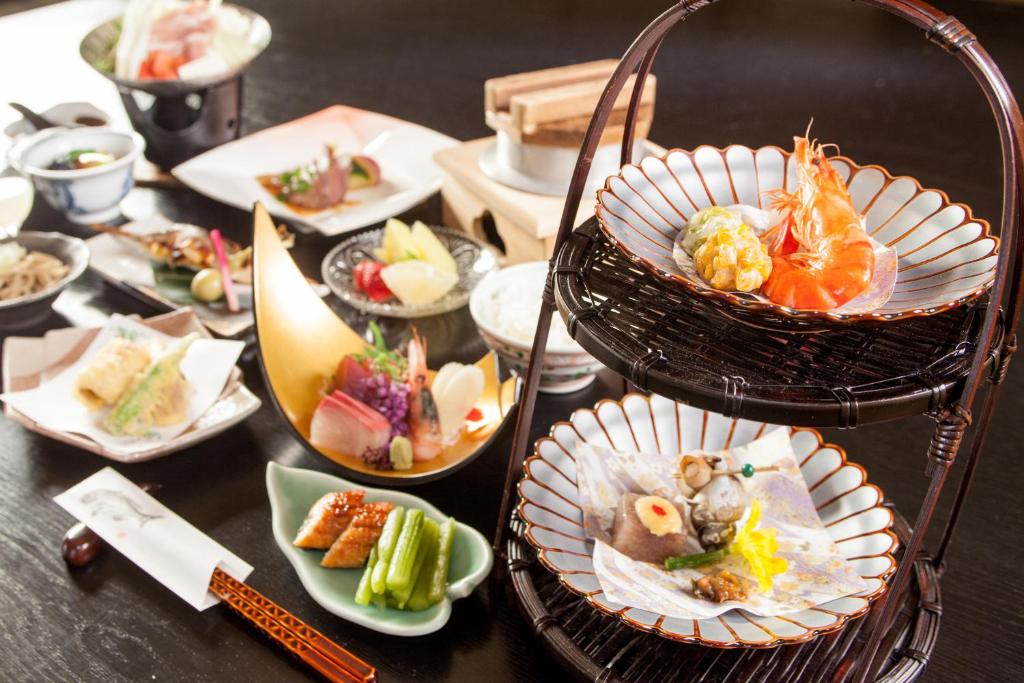 une table avec de nombreuses assiettes de nourriture dessus dans l'établissement Hotel Taiko, à Myōkō