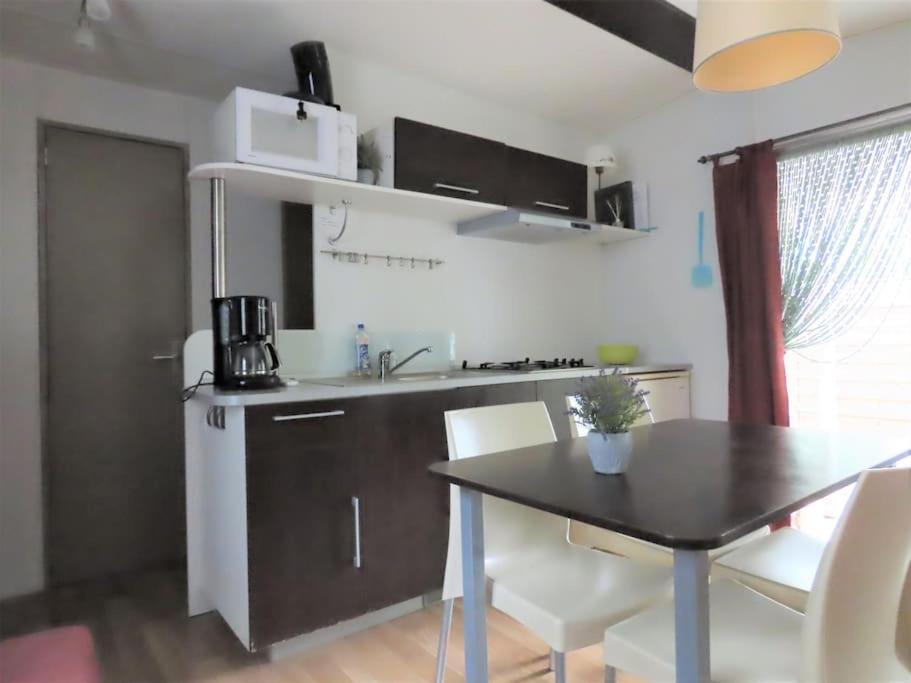 une cuisine avec une table et une salle à manger dans l'établissement Mobile home 6-pers Camping Leï Suves-Côtes d'Azur-including airco, à Roquebrune-sur Argens