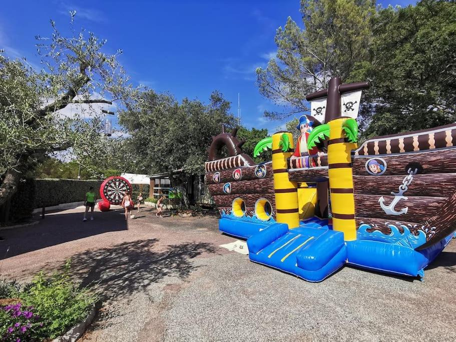 une aire de jeux pour enfants avec une structure ludique colorée dans l'établissement Mobile home 6-pers Camping Leï Suves-Côtes d'Azur-including airco, à Roquebrune-sur Argens