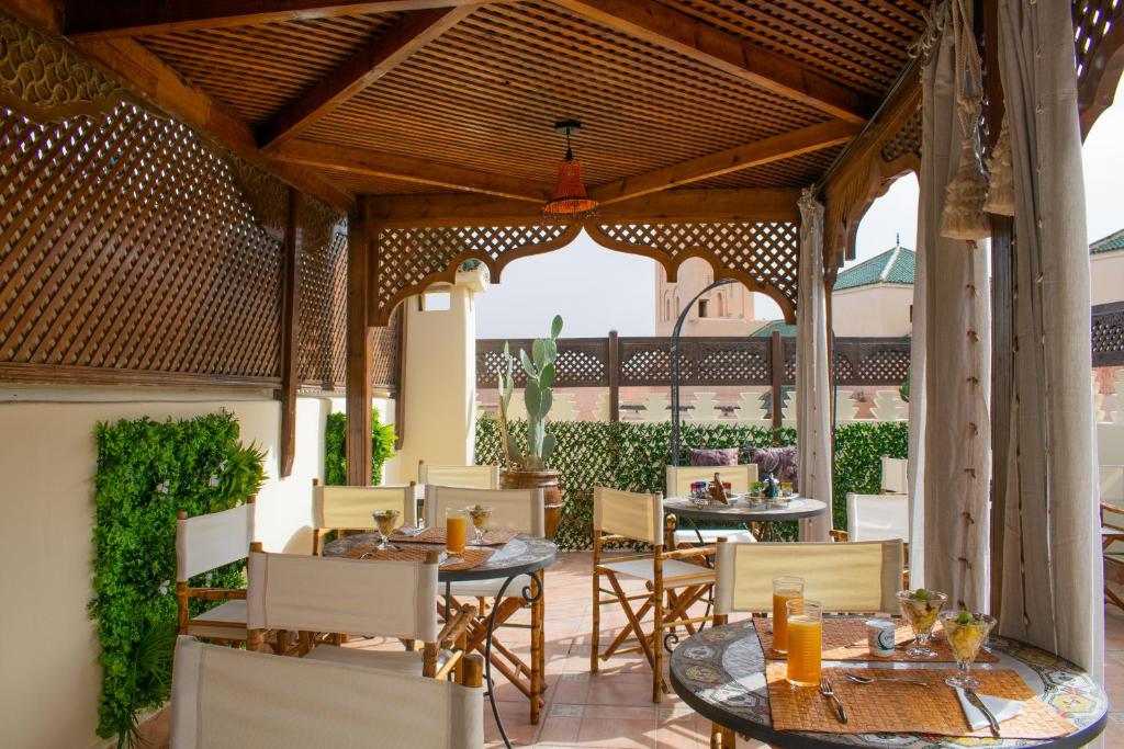 - un coin repas extérieur avec des tables et des chaises dans l'établissement Perlekech Riad & Spa, à Marrakech