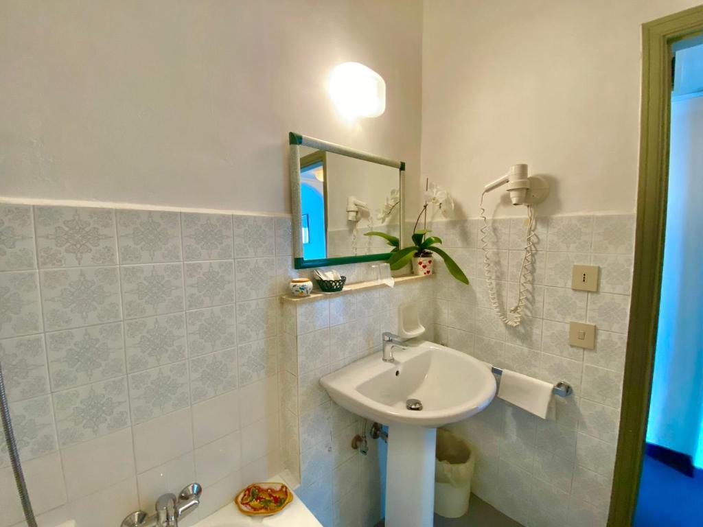 une salle de bain avec un lavabo et un miroir dans l'établissement Hotel Kennedy, à SantʼAlessio Siculo