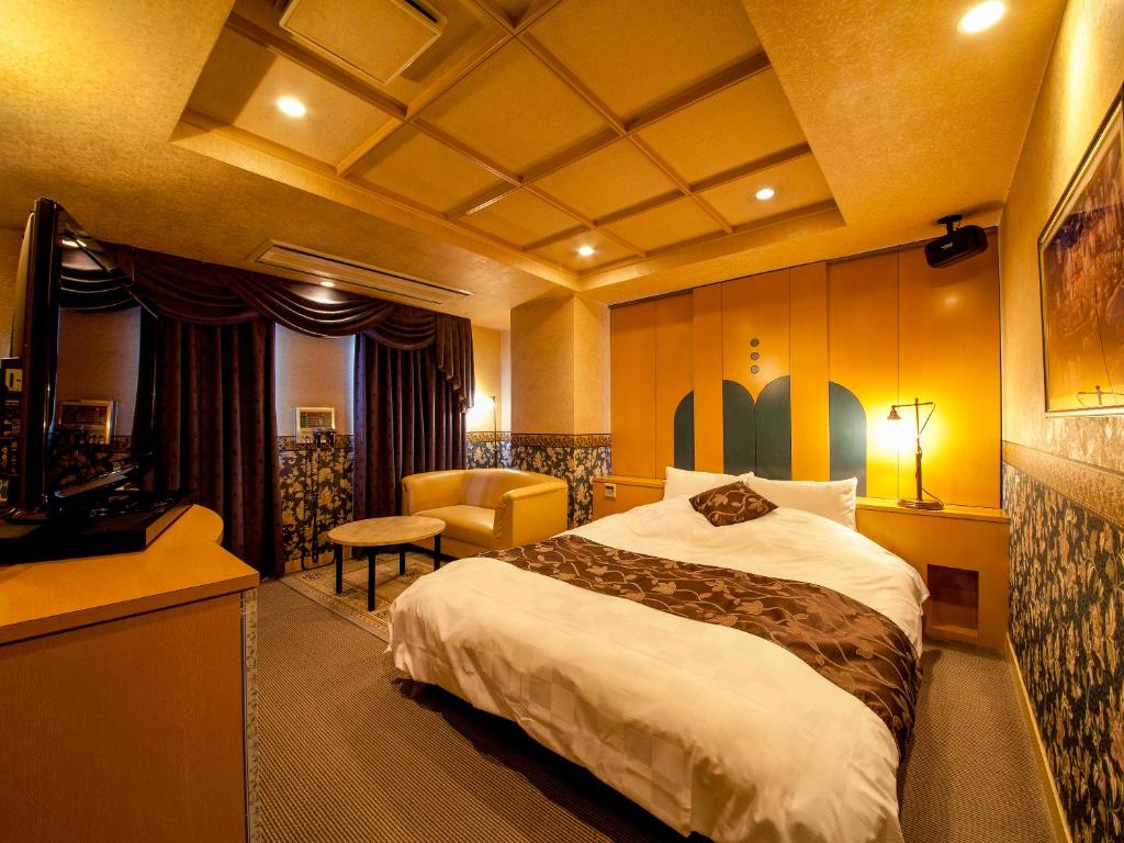 une chambre d'hôtel avec un lit et une chaise dans l'établissement Saint martin (Adult Only), à Kyoto