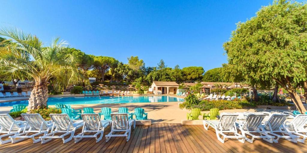 une terrasse avec des chaises et une piscine dans l'établissement Mobile home 6-pers Camping Leï Suves-Côtes d'Azur-including airco, à Roquebrune-sur Argens