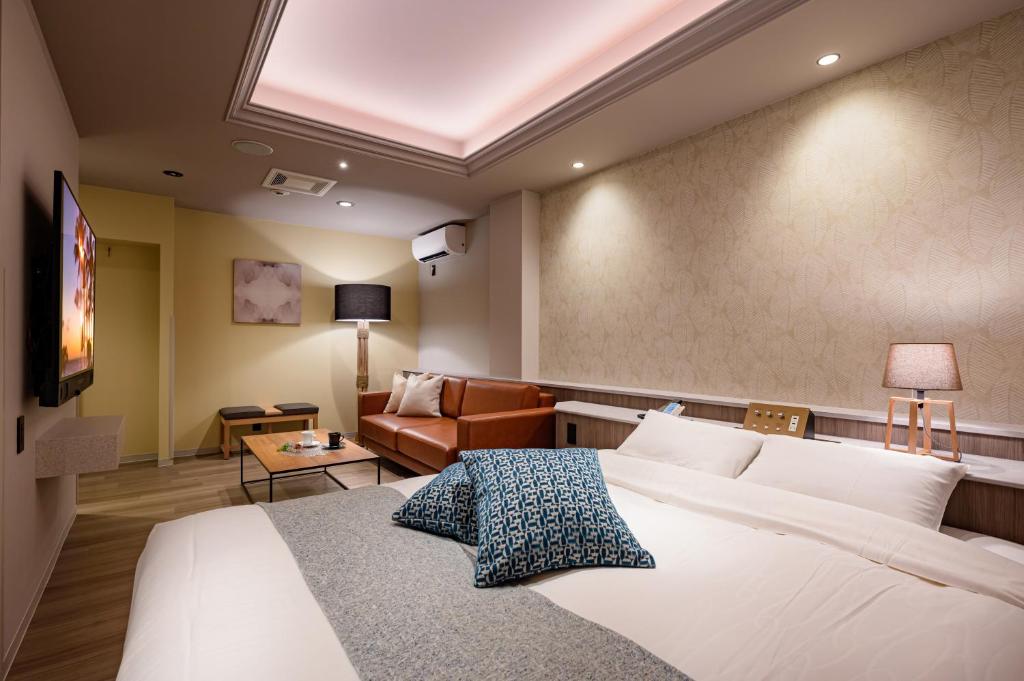 une chambre d'hôtel avec un lit et un canapé dans l'établissement BAMBOO GARDEN 相模原, à Sagamihara