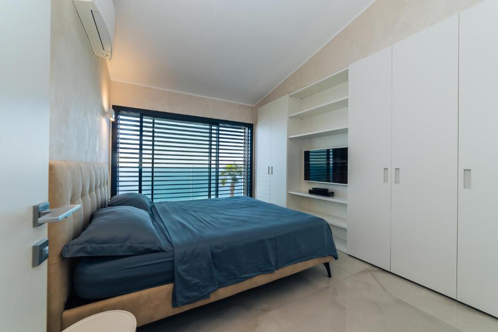 une chambre avec un lit et une grande fenêtre dans l'établissement Villa Sabrina Riviera dei Fiori a Picco sul Mare con Piscina Privata ,WELLNESS & SPA, à Imperia