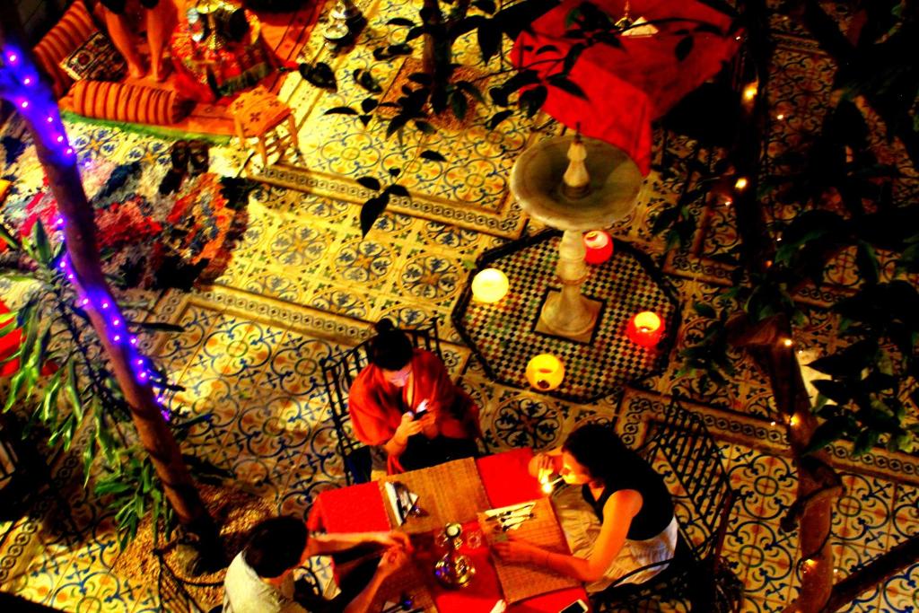 un groupe de personnes assises à une table dans une pièce dans l'établissement Riad Al Nour, à Marrakech