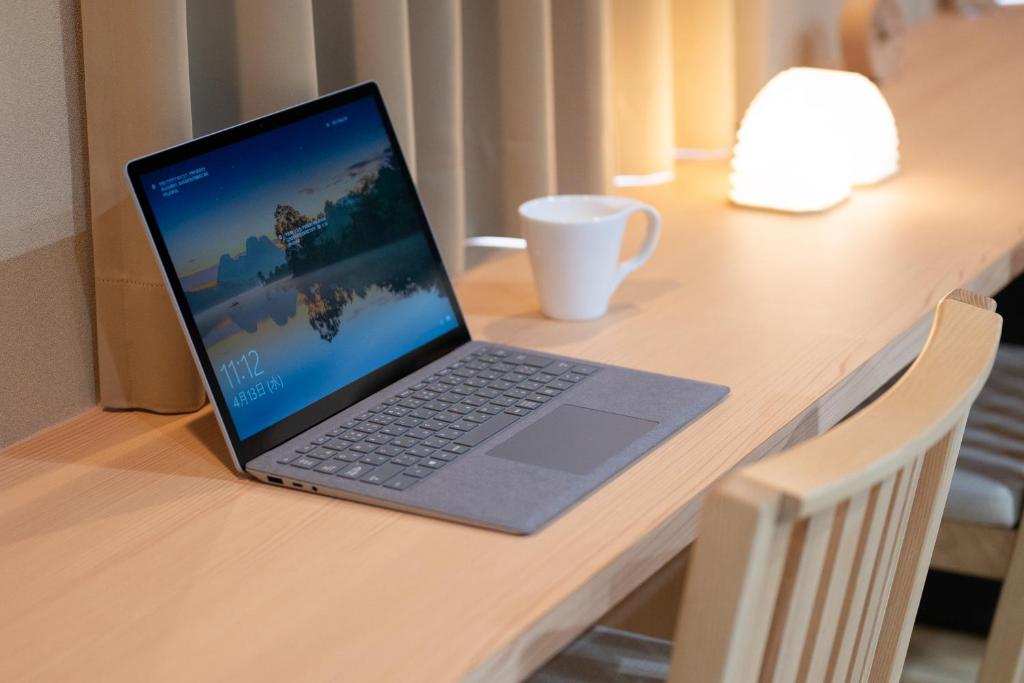 un ordinateur portable installé au-dessus d'un bureau en bois dans l'établissement Hotel Sugicho, à Kyoto