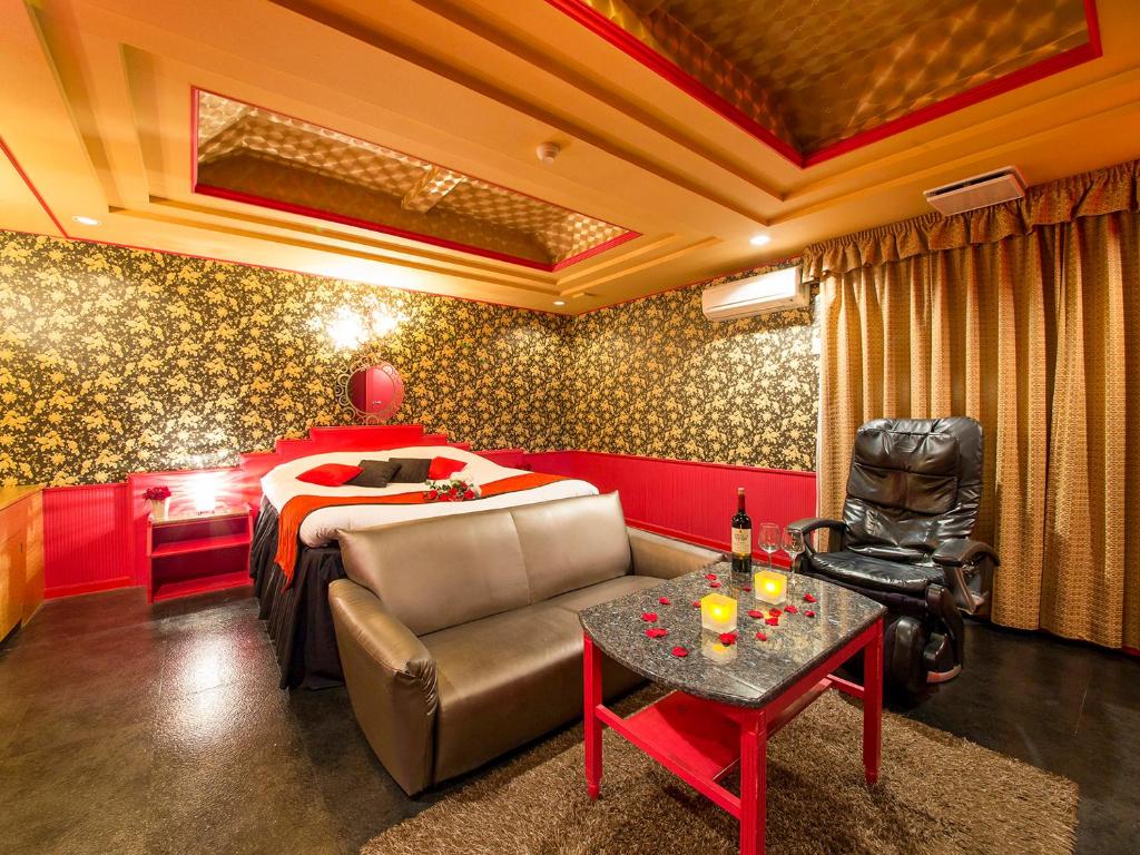 une chambre avec un lit, un canapé et une table dans l'établissement Hotel Gallery (Adult Only), à Kobe