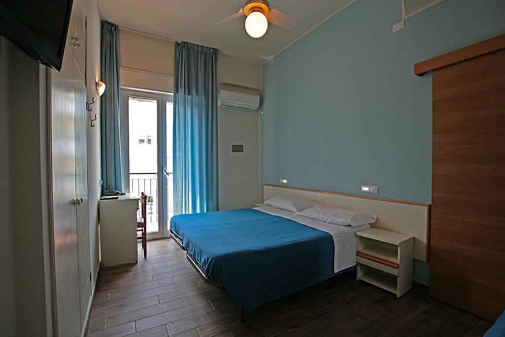une chambre avec un lit avec une couverture bleue dans l'établissement Hotel Sayonara, à Cattolica