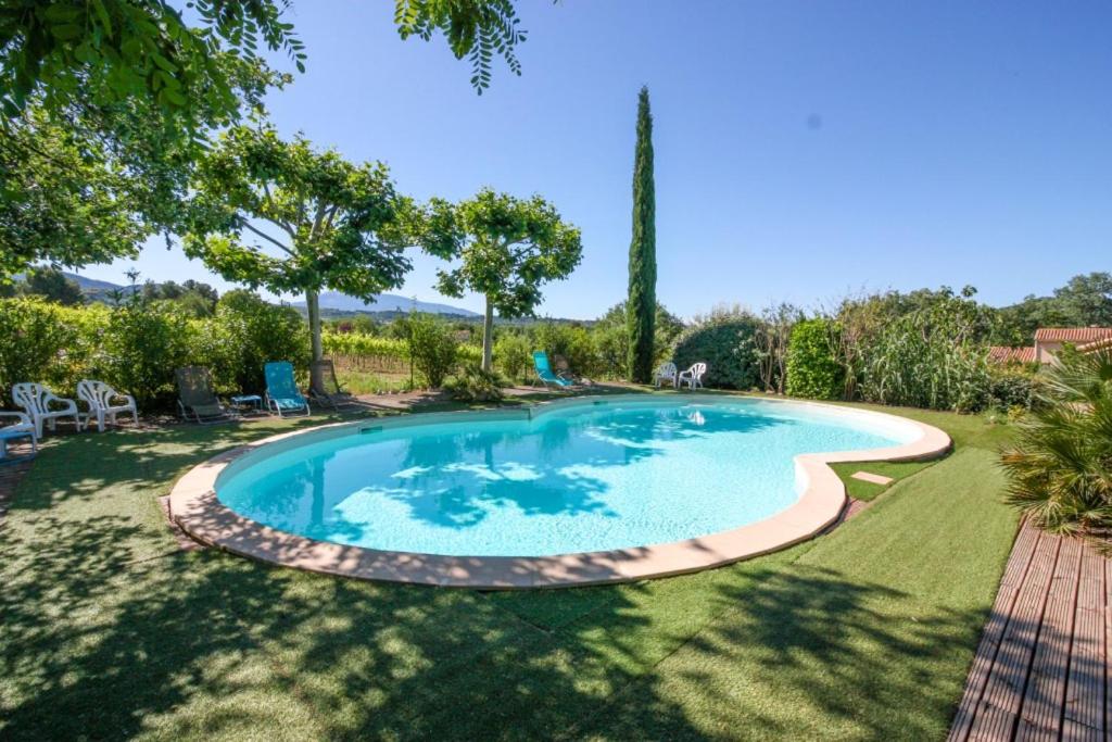 - une piscine dans une cour avec des chaises et des arbres dans l'établissement La Françonne Rosé - Gîte de charme en Provence, à Mirabel-aux-Baronnies