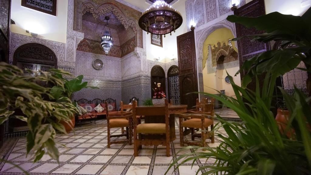 une salle à manger avec une table et des plantes dans l'établissement Riad Fes Palacete, à Fès