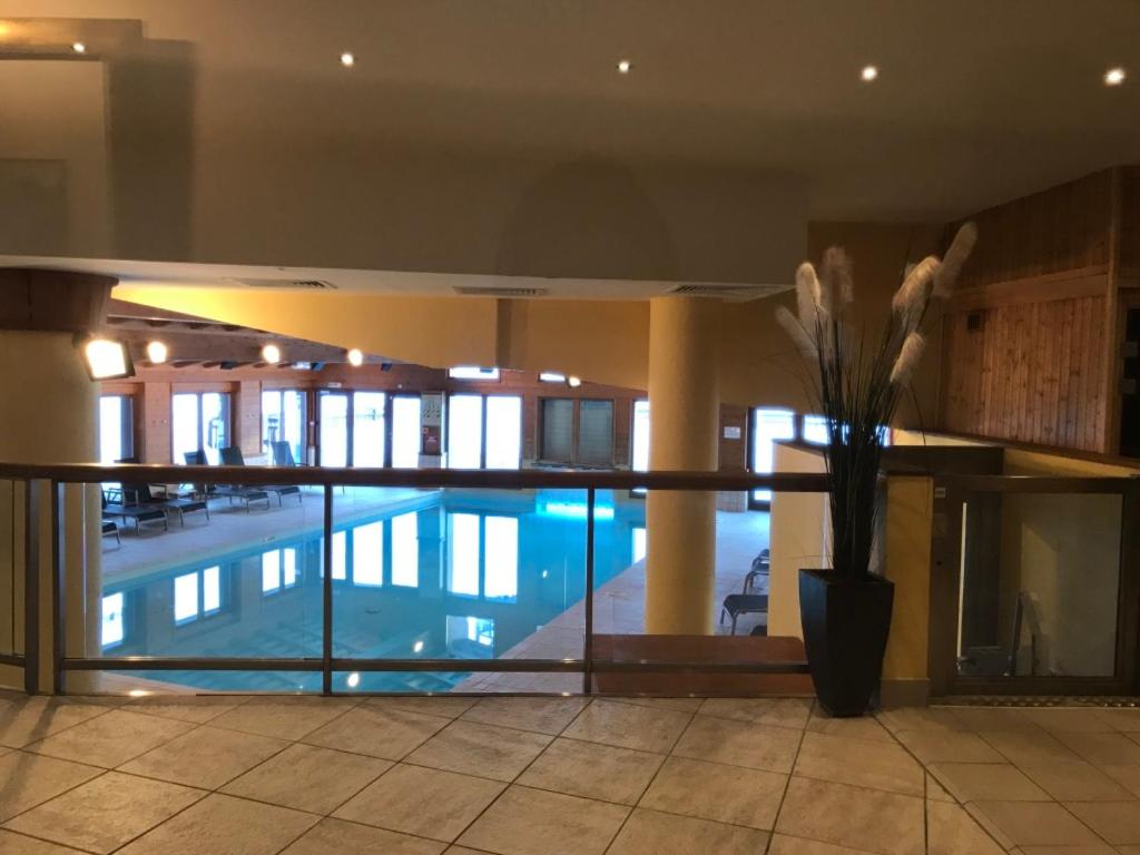 - une piscine dans un bâtiment avec un vase de fleurs dans l'établissement Arc 1950 - Charmant Appart 2-4 pers dans résidence hôtelière, Skis aux pieds, à Arc 1950