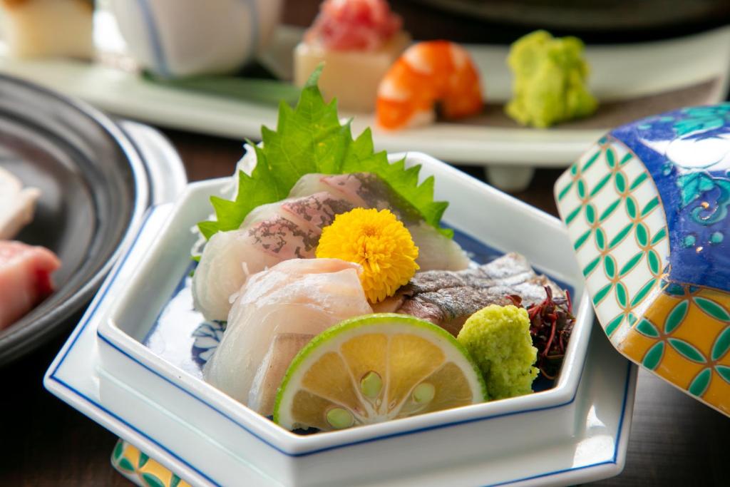 un plat de nourriture avec du poisson et des légumes sur une table dans l'établissement Oyado Ichizen, à Yufu