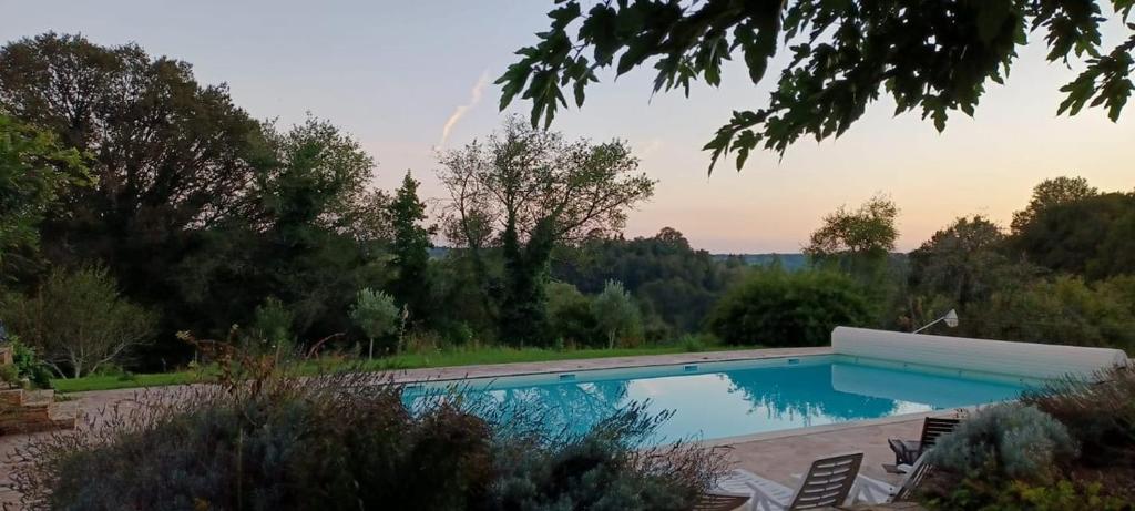 une piscine au milieu d'un jardin dans l'établissement Roulotte à Sapharey, à Sarrazac