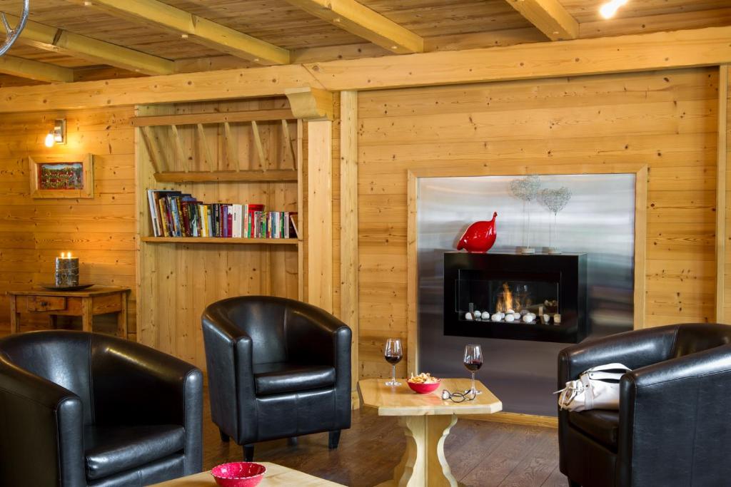 un salon avec deux chaises et une cheminée dans l'établissement Hôtel Le Sporting, à Morzine