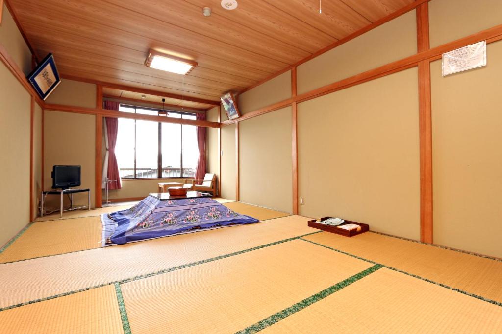 une chambre avec un lit et une télévision dans l'établissement Sugakuso, à Yamanakako 37 autres photos
