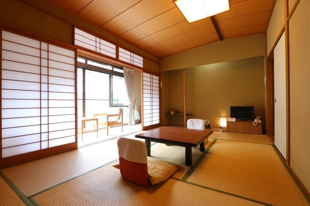 un salon avec une table et une fenêtre dans l'établissement Kamiobo, à Kobe