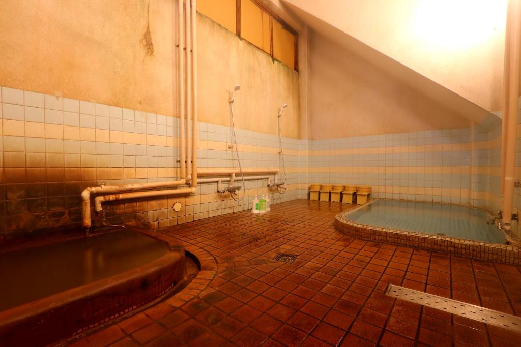 une salle de bain avec baignoire dans une chambre dans l'établissement Kamiobo, à Kobe