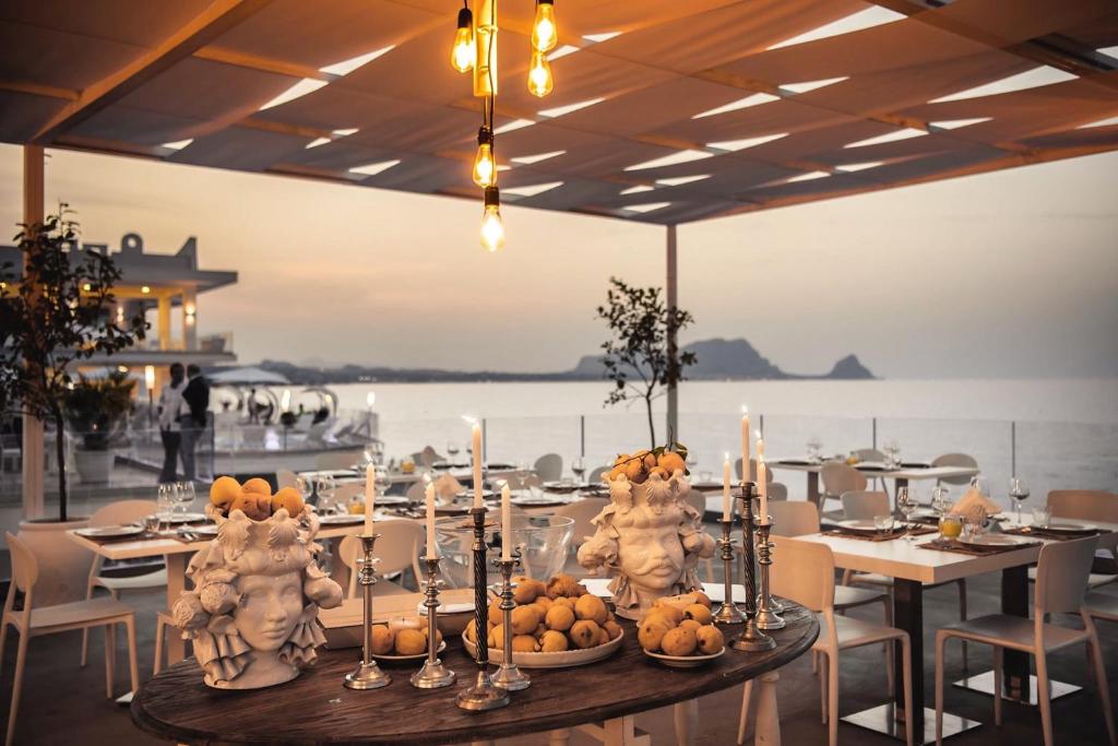 une salle à manger avec une table avec des fruits et des bougies dans l'établissement Hotel Sporting Club, à Altavilla Milicia