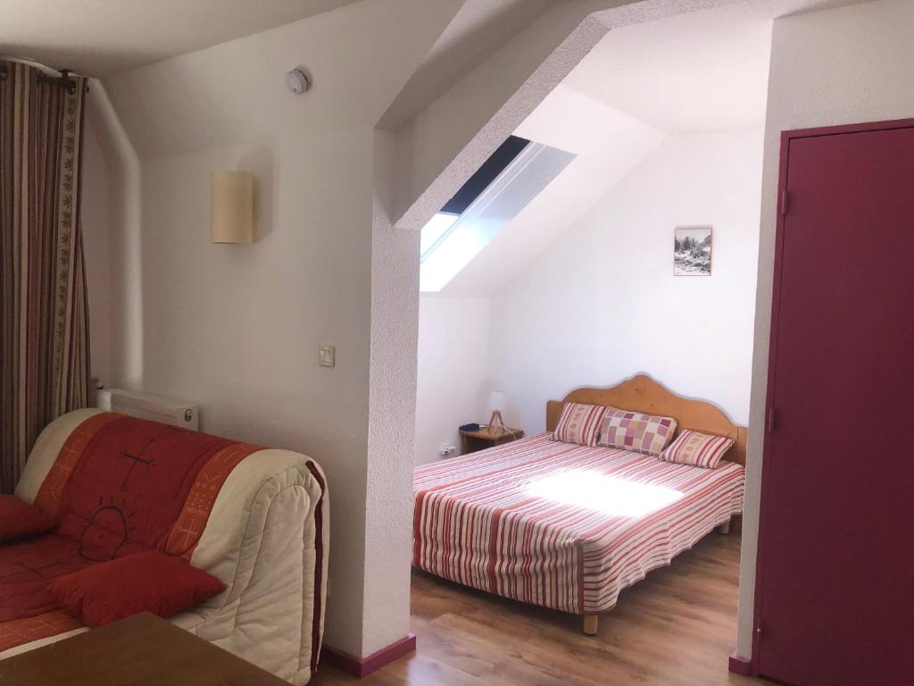une chambre avec un lit et un canapé dans une pièce dans l'établissement T1 bis A CAUTERETS - 4 VOYAGEURS, à Cauterets