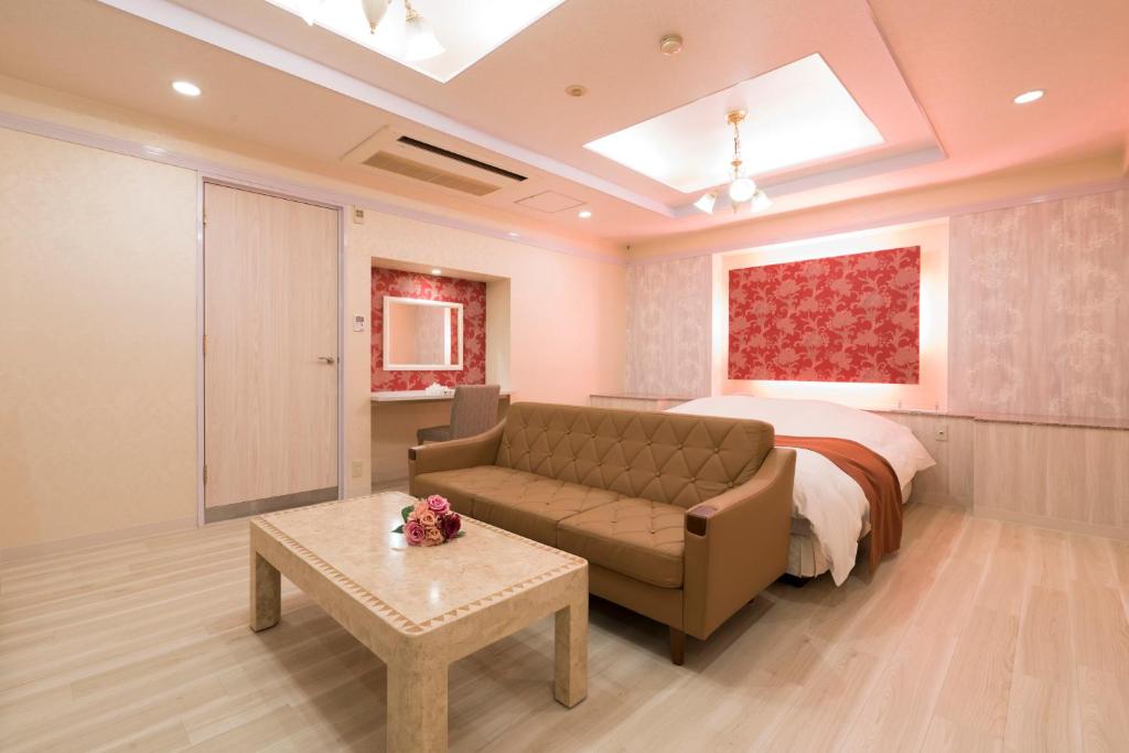 une chambre avec un lit, un canapé et une table dans l'établissement Hotel Rea Tiare - Adult Only-, à Himeji