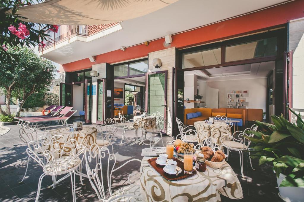 un groupe de tables et de chaises sur une terrasse dans l'établissement Ligure Residence Appartamenti per Vacanze, à Pietra Ligure