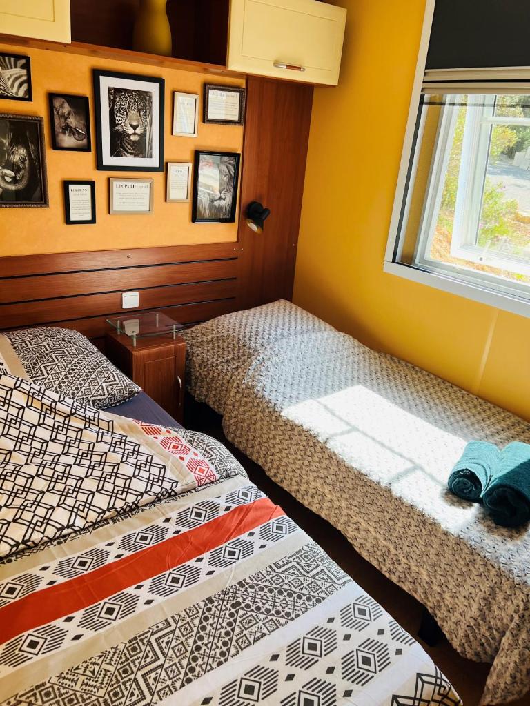deux lits dans une chambre avec une fenêtre dans l'établissement Joli Mobil-Home de Vacances, Ideal pour les familles, à Rocbaron