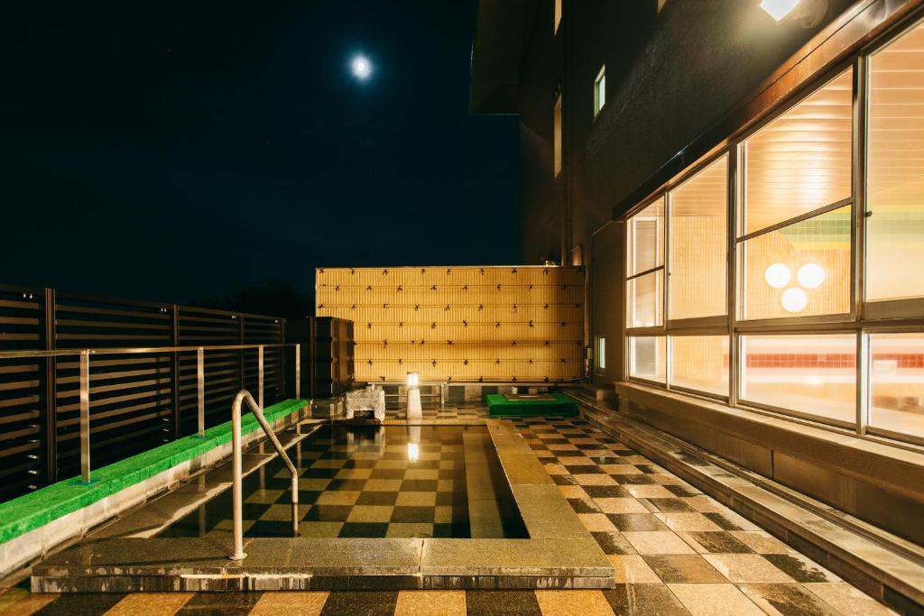 une pièce avec un sol en damier dans un immeuble dans l'établissement KAMENOI HOTEL Tondabayashi, à Tondabayashi