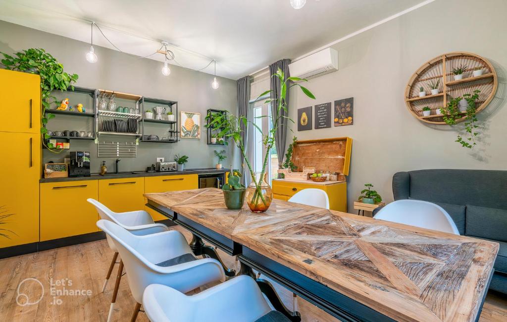 une cuisine avec une grande table en bois et des chaises blanches dans l'établissement Al Quadrato, à Piobbico