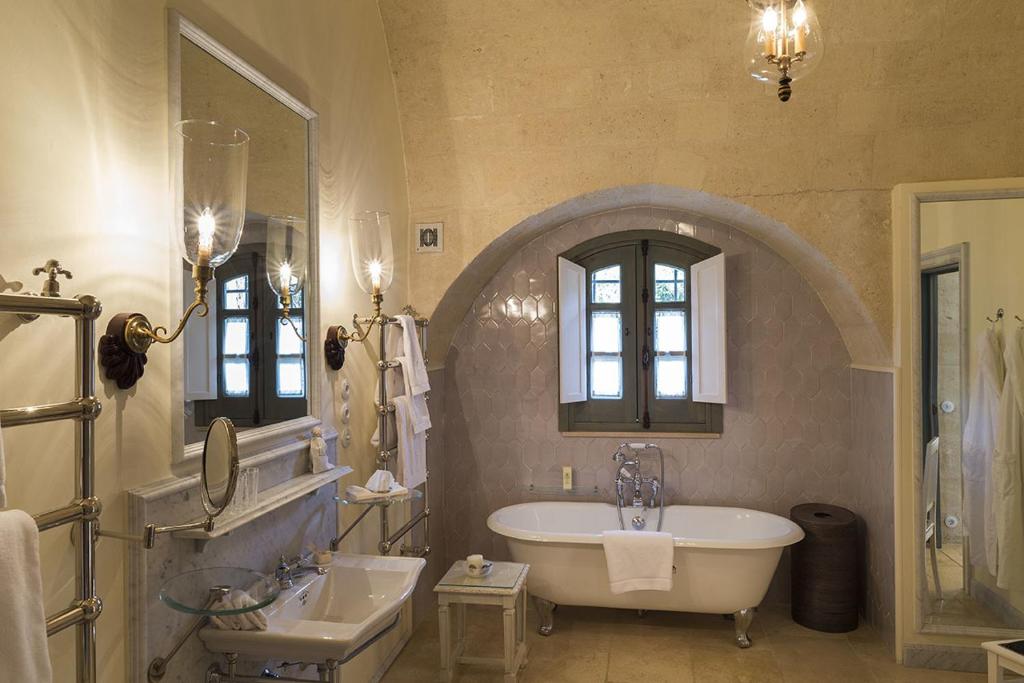 une grande salle de bain avec une baignoire et un lavabo dans l'établissement Palazzo Margherita, à Bernalda