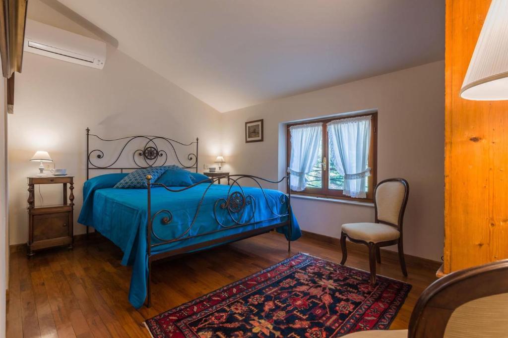 - une chambre avec un lit bleu, une chaise et une fenêtre dans l'établissement Villa Panorama, à Pesaro 39 autres photos