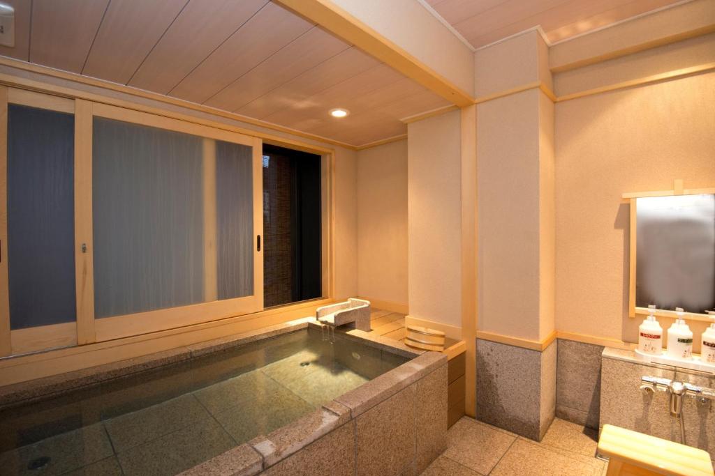 La salle de bains est pourvue d'une piscine et d'une télévision. dans l'établissement こんぴら温泉 貸切湯の宿 ことね, à Kotohira