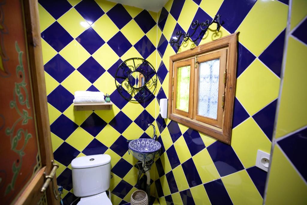 La salle de bains est pourvue d'un mur en damier jaune et bleu. dans l'établissement Riad Moroccan Style, à Fès 37 autres photos