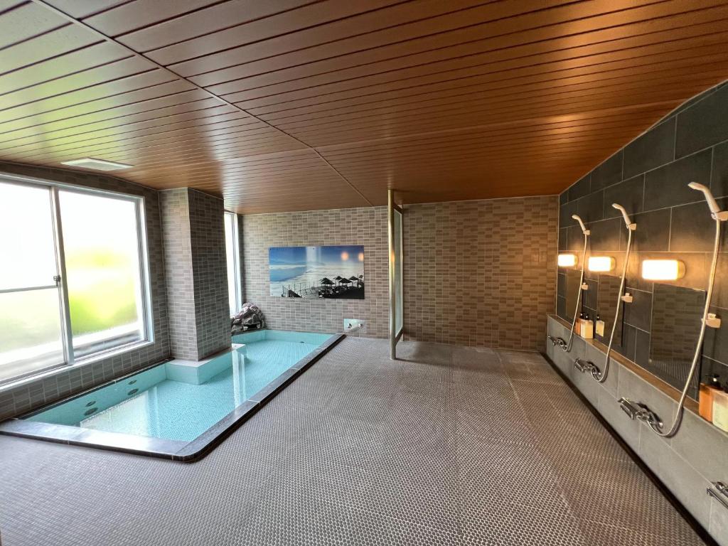 une grande salle de bains avec une piscine. dans l'établissement Kitashiga Holiday Inn, à Yamanouchi