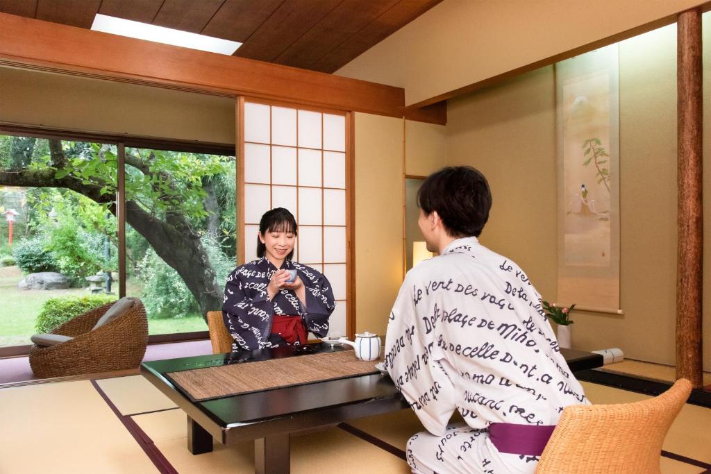 un homme et une femme en kimono assis à une table dans l'établissement Hotel Hagoromo, à Shizuoka 37 autres photos