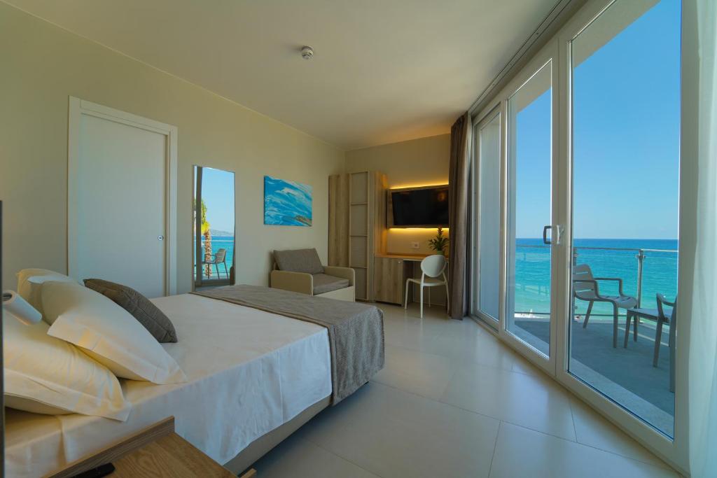 une chambre avec un lit et une vue sur l'océan dans l'établissement Eleamare Resort, à Castellammare di Velia