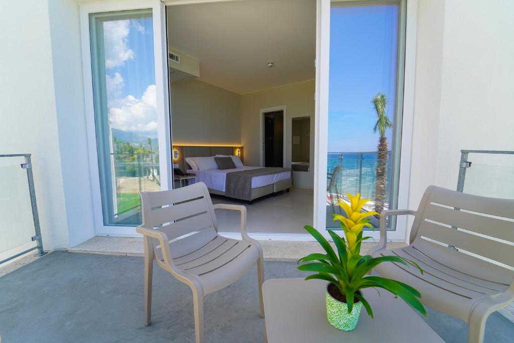 d'un salon avec deux chaises et un canapé sur un balcon. dans l'établissement Eleamare Resort, à Castellammare di Velia