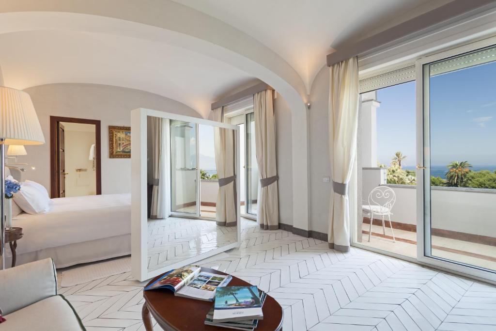 une chambre d'hôtel avec un lit et une grande fenêtre dans l'établissement Grand Hotel Cocumella, à Sant'Agnello