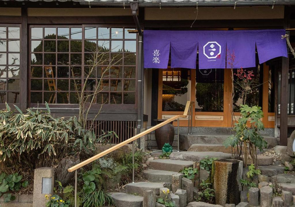 un bâtiment avec une bannière violette à l'avant dans l'établissement Ryokan Kiraku, à Beppu