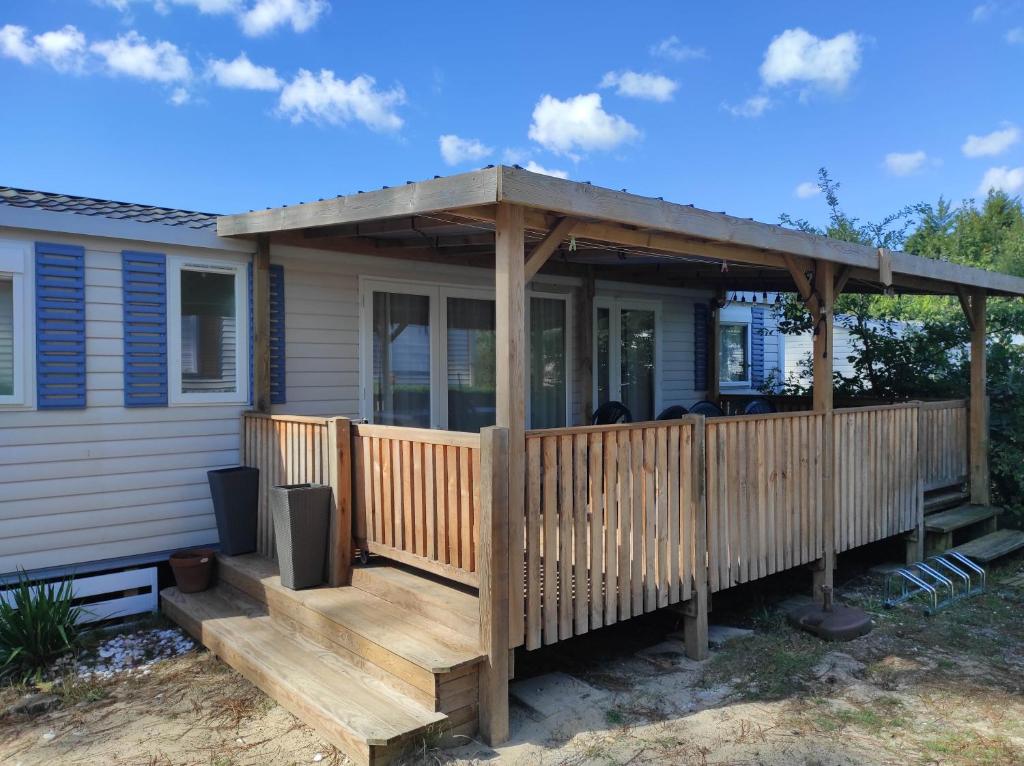 une terrasse avec pergola sur une maison dans l'établissement Mobil-home spacieux, au calme, proche Mimizan, à Bias