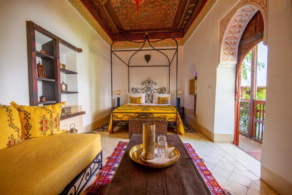 un salon avec un canapé et un lit dans l'établissement Riad Dombaraka, à Marrakech