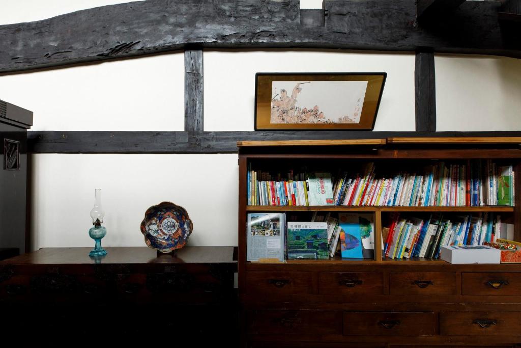 une chambre avec une étagère et des livres dans l'établissement Busuitei, à Hida