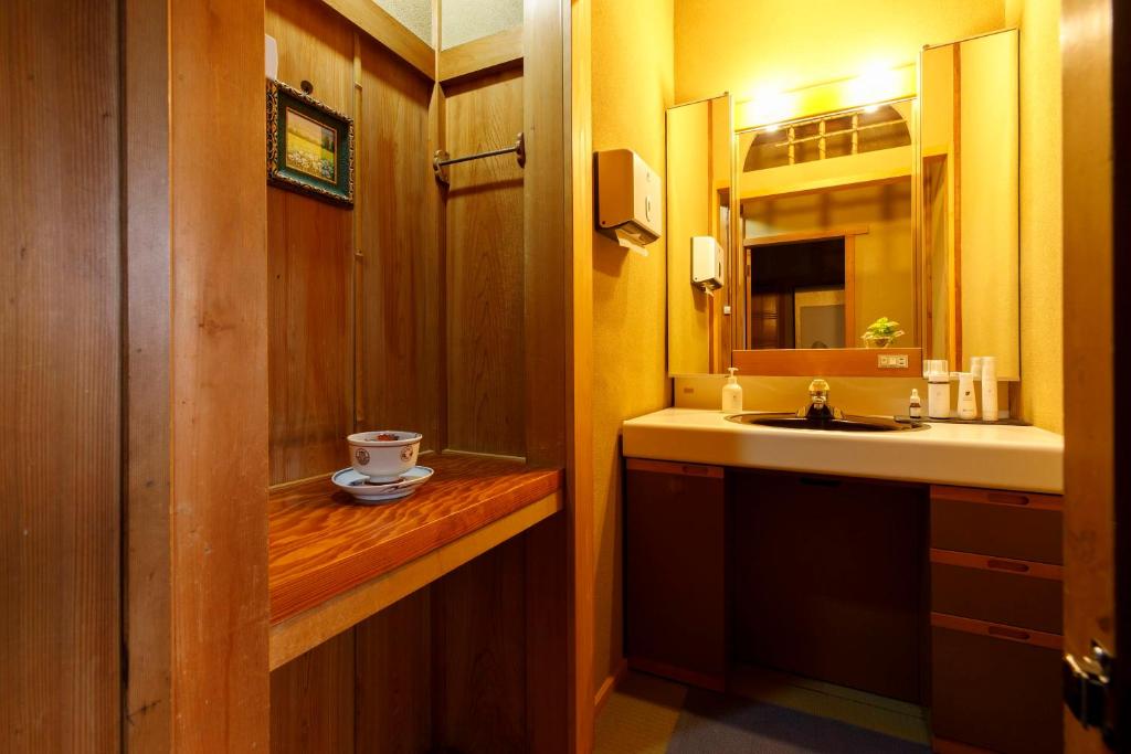 une salle de bain avec un lavabo et un miroir dans l'établissement Busuitei, à Hida 37 autres photos