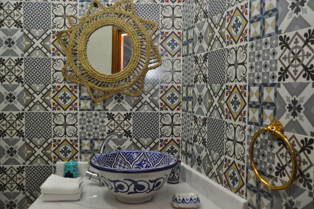 - une salle de bains avec un bol bleu et blanc et un miroir dans l'établissement Dar Aouinti, à Marrakech 34 autres photos